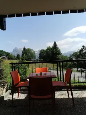 a table and chairs on a balcony with a view at le Nid Douillet au pied de Megève in Demi-Quartier