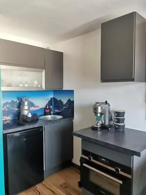 a kitchen with a black counter and a sink at le Nid Douillet au pied de Megève in Demi-Quartier