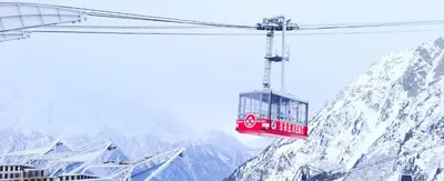 a red cable car flying over a snow covered mountain at Le Cristal MT10 - Central Apartment - Close to ski lift - FreeParking in Chamonix-Mont-Blanc