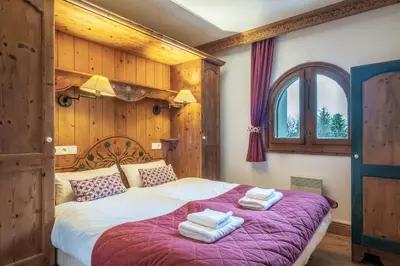 a bedroom with a large bed with towels on it at Le Cristal MT10 - Central Apartment - Close to ski lift - FreeParking in Chamonix-Mont-Blanc