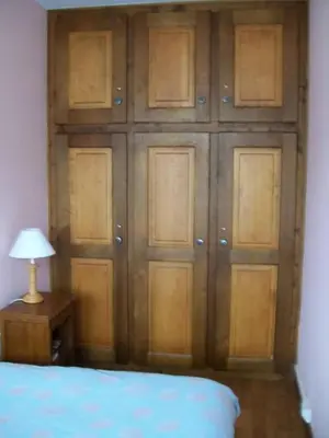 a bedroom with a wall of wooden doors at LE CLOS DE RENNEs in Megève