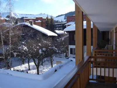a snow covered balcony with a view of the mountains at LE CLOS DE RENNEs in Megève