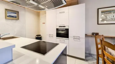 a kitchen with white cabinets and a sink at Résidence Capricorne - Appartement entièrement rénové avec cabine · Au pied des pistes · Balcon MAE-5034 in Magland