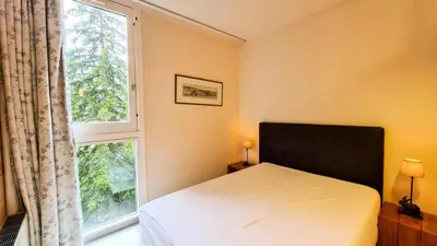 a bedroom with a bed and a large window at Résidence Capricorne - Appartement entièrement rénové avec cabine · Au pied des pistes · Balcon MAE-5034 in Magland