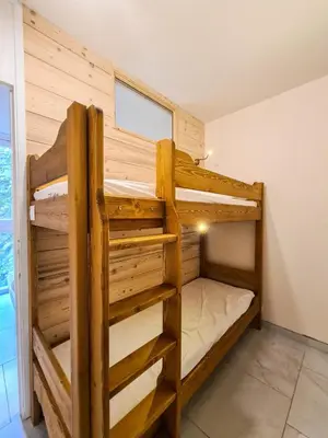 a bedroom with two bunk beds in a room at Résidence Capricorne - Appartement entièrement rénové avec cabine · Au pied des pistes · Balcon MAE-5034 in Magland