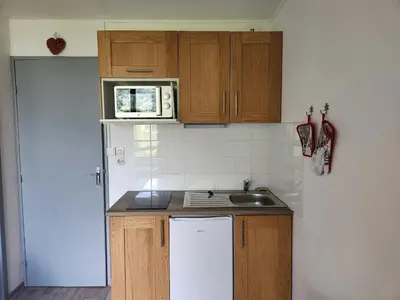 a small kitchen with a table and a counter top at Studio 19m² à Samoëns, 4 pers, animaux admis, parking - FR-1-629-144 in Samoëns