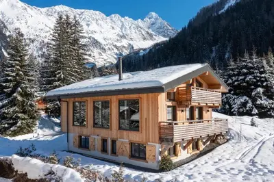 a log cabin in the snow with mountains at Chalet Les Grands Montets in Chamonix-Mont-Blanc