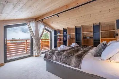 a bedroom with a large bed and a large window at Chalet Les Grands Montets in Chamonix-Mont-Blanc