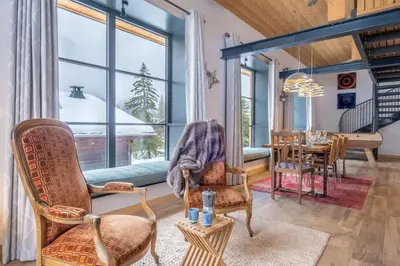 a living room with a table and chairs and a large window at Chalet Les Grands Montets in Chamonix-Mont-Blanc