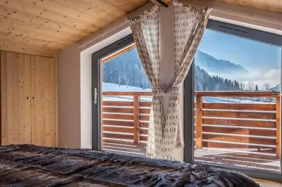 a bedroom with a large window with a mountain view at Chalet Les Grands Montets in Chamonix-Mont-Blanc