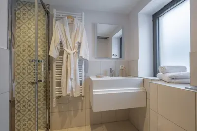 a white bathroom with a sink and a shower at Chalet Les Grands Montets in Chamonix-Mont-Blanc