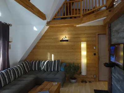 a living room with a couch and a wooden wall at Les Terrasses des Glaciers - Appartement 2 in Chamonix-Mont-Blanc