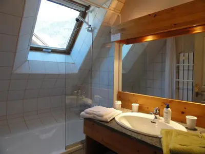 a bathroom with a sink and a mirror and a tub at Les Terrasses des Glaciers - Appartement 2 in Chamonix-Mont-Blanc
