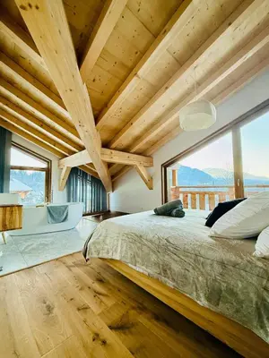 a bedroom with a large bed and a large window at Chalet Monarch - Les Carroz - Sauna, Spa & vue Montagnes in Arâches-la-Frasse