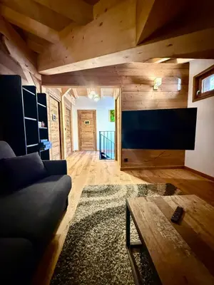 a living room with a couch and a large flat screen tv at Chalet Monarch - Les Carroz - Sauna, Spa & vue Montagnes in Arâches-la-Frasse