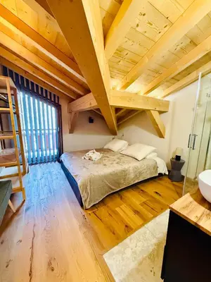 a bedroom with a bed in a room with wooden ceilings at Chalet Monarch - Les Carroz - Sauna, Spa & vue Montagnes in Arâches-la-Frasse
