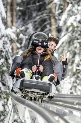 a man and a woman riding on a ski lift at Chalet Monarch - Les Carroz - Sauna, Spa & vue Montagnes in Arâches-la-Frasse