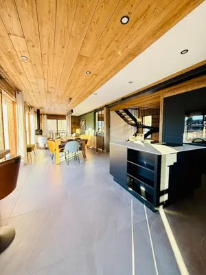 a kitchen with a wooden ceiling and a dining room at Chalet Monarch - Les Carroz - Sauna, Spa & vue Montagnes in Arâches-la-Frasse