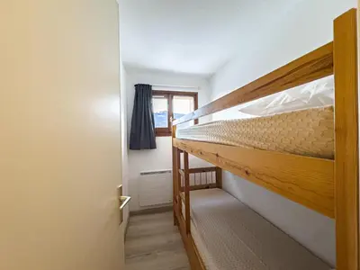 a bedroom with two bunk beds and a window at Appartement Proche Des Pistes By TerraAlpina in Saint-Gervais-les-Bains