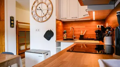 a kitchen with a large clock on the wall at Appartement Proche Des Pistes By TerraAlpina in Saint-Gervais-les-Bains