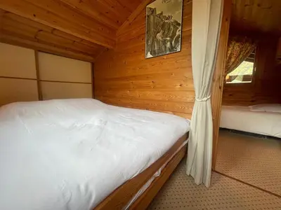 a bedroom with two beds in a wooden cabin at Chalet paisible avec cheminée et animaux acceptés près des pistes - FR-1-624-176 in Sixt