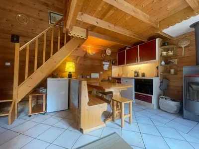 a kitchen with a wooden staircase in a cabin at Chalet paisible avec cheminée et animaux acceptés près des pistes - FR-1-624-176 in Sixt