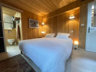 a bedroom with a large white bed in a room at Chalet paisible avec cheminée et animaux acceptés près des pistes - FR-1-624-176 in Sixt