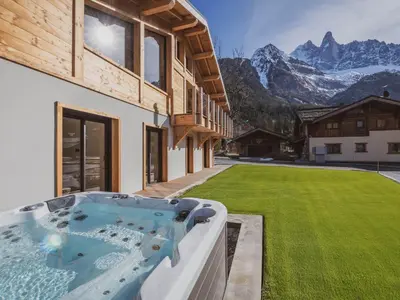 a large wooden house with a deck on top at Chalet avec jacuzzi et animaux admis, vue Mont-Blanc - FR-1-343-259 in Chamonix-Mont-Blanc