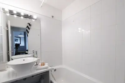 a white bathroom with a sink and a tub at Au Coin du Mont Blanc in Chamonix-Mont-Blanc