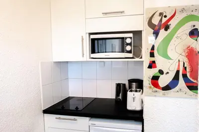 a kitchen with white cabinets and a microwave at Au Coin du Mont Blanc in Chamonix-Mont-Blanc