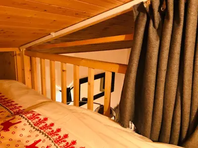 a bedroom with a bed and a window with curtains at Cosy duplex with Hammam-Steamroom in Rochebrune in Megève