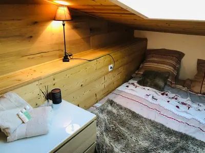 a bed in a room with a lamp on a table at Cosy duplex with Hammam-Steamroom in Rochebrune in Megève