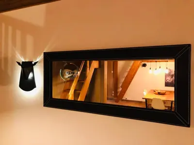 a mirror hanging on a wall with a table at Cosy duplex with Hammam-Steamroom in Rochebrune in Megève