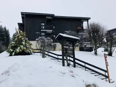 a building with a sign in the snow at Cosy duplex with Hammam-Steamroom in Rochebrune in Megève