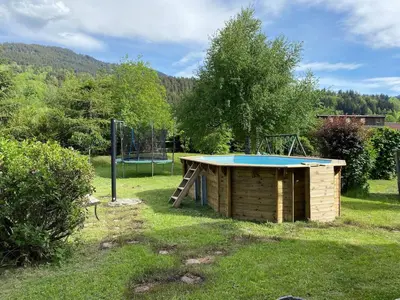 a building with a trampoline in the grass with a trampoline at Chalet vue montagne , proche des pistes in Megève