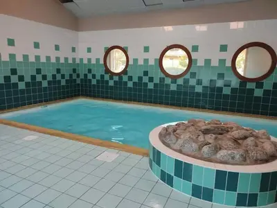 a swimming pool with two windows and a tub of water at Studio Résidence grand tetras in Samoëns