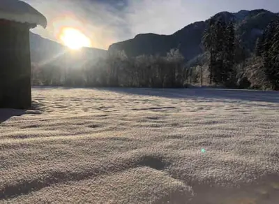 a frozen lake with the sun setting in the background at Studio Résidence grand tetras in Samoëns