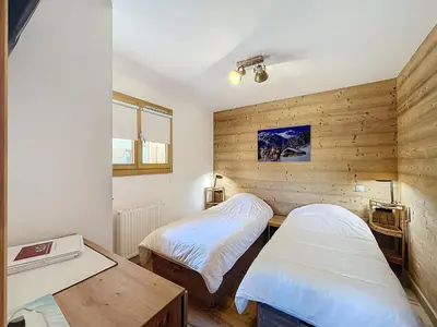 two beds in a room with wooden walls and a table at Appartement standing à Combloux avec balcon et parking - FR-1-560-156 in Combloux