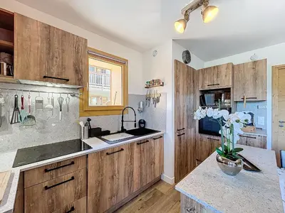 a kitchen with wooden cabinets and a counter top at Appartement standing à Combloux avec balcon et parking - FR-1-560-156 in Combloux