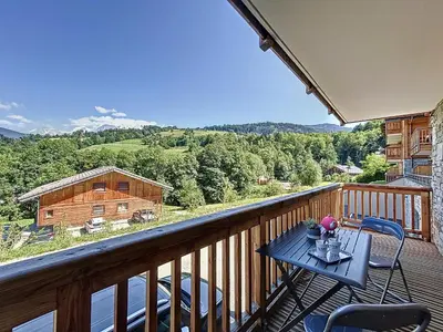 a balcony with a table and chairs on a deck at Appartement standing à Combloux avec balcon et parking - FR-1-560-156 in Combloux