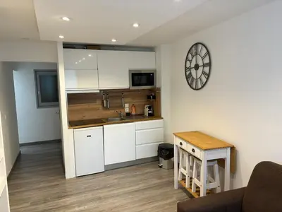 a kitchen with white cabinets and a clock on the wall at Le Flocon - Centre - Megève - Wifi - Duplex in Megève