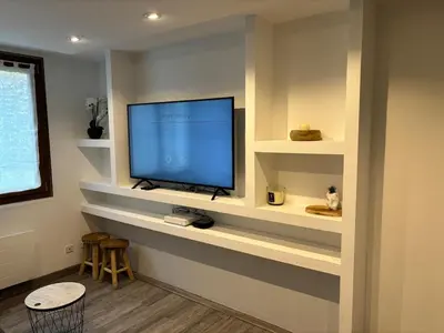 a living room with a flat screen tv on a wall at Le Flocon - Centre - Megève - Wifi - Duplex in Megève