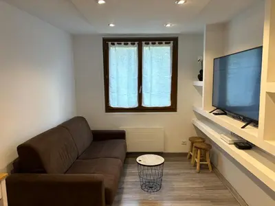 a living room with a couch and a flat screen tv at Le Flocon - Centre - Megève - Wifi - Duplex in Megève