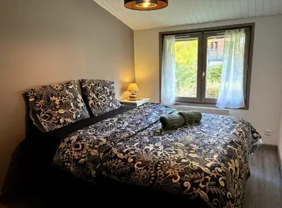 a bedroom with a large bed with a large window at Le Flocon - Centre - Megève - Wifi - Duplex in Megève