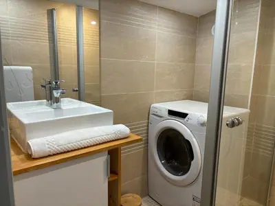 a bathroom with a washing machine and a sink at Le Flocon - Centre - Megève - Wifi - Duplex in Megève