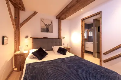 a bedroom with a large bed with two pillows at Chalet Les Rots Home in Samoëns