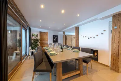 a dining room with a table and chairs and a fireplace at Chalet Les Rots Home in Samoëns