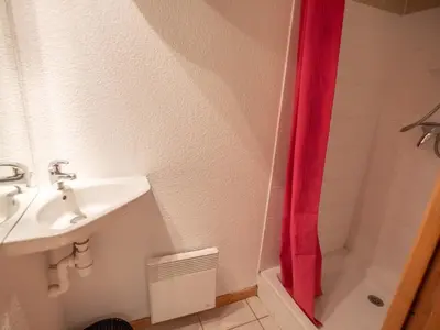 a bathroom with a sink and a red shower curtain at Parfait pour 6 personnes au pied des télécabines in Saint-Gervais-les-Bains