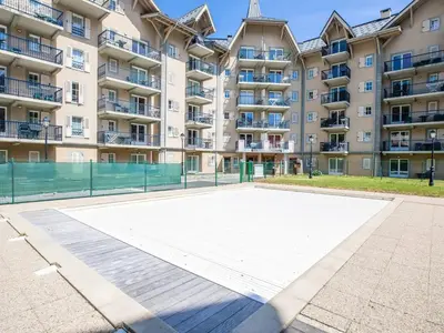 an empty basketball court in front of a large apartment building at Parfait pour 6 personnes au pied des télécabines in Saint-Gervais-les-Bains