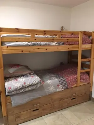 a bedroom with a bunk bed and a closet at Appartement de charme familial aux CARROZ d ARACHES in Arâches-la-Frasse